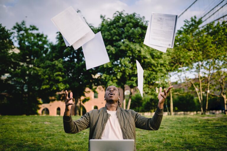 man throwing resumes into the air