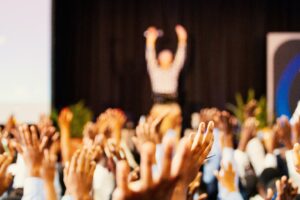 people raising their hands at a group conference