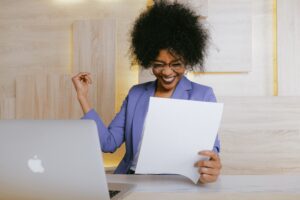 a woman excited looking at a piece of paper.