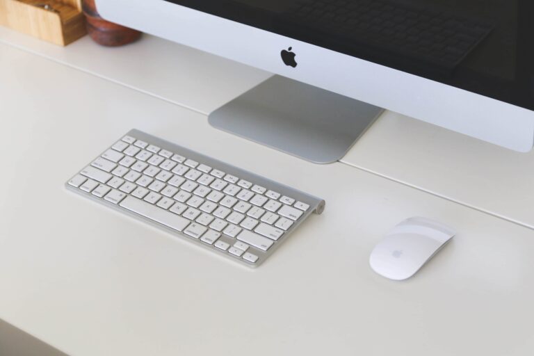 An apple computer, keyboard, and mouse.